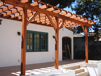 A Construction Heart redwood pergola attached to a Spanish style home.

